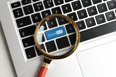 Image of Light blue button with word Email and illustration of envelope on computer keyboard, view through magnifying glass