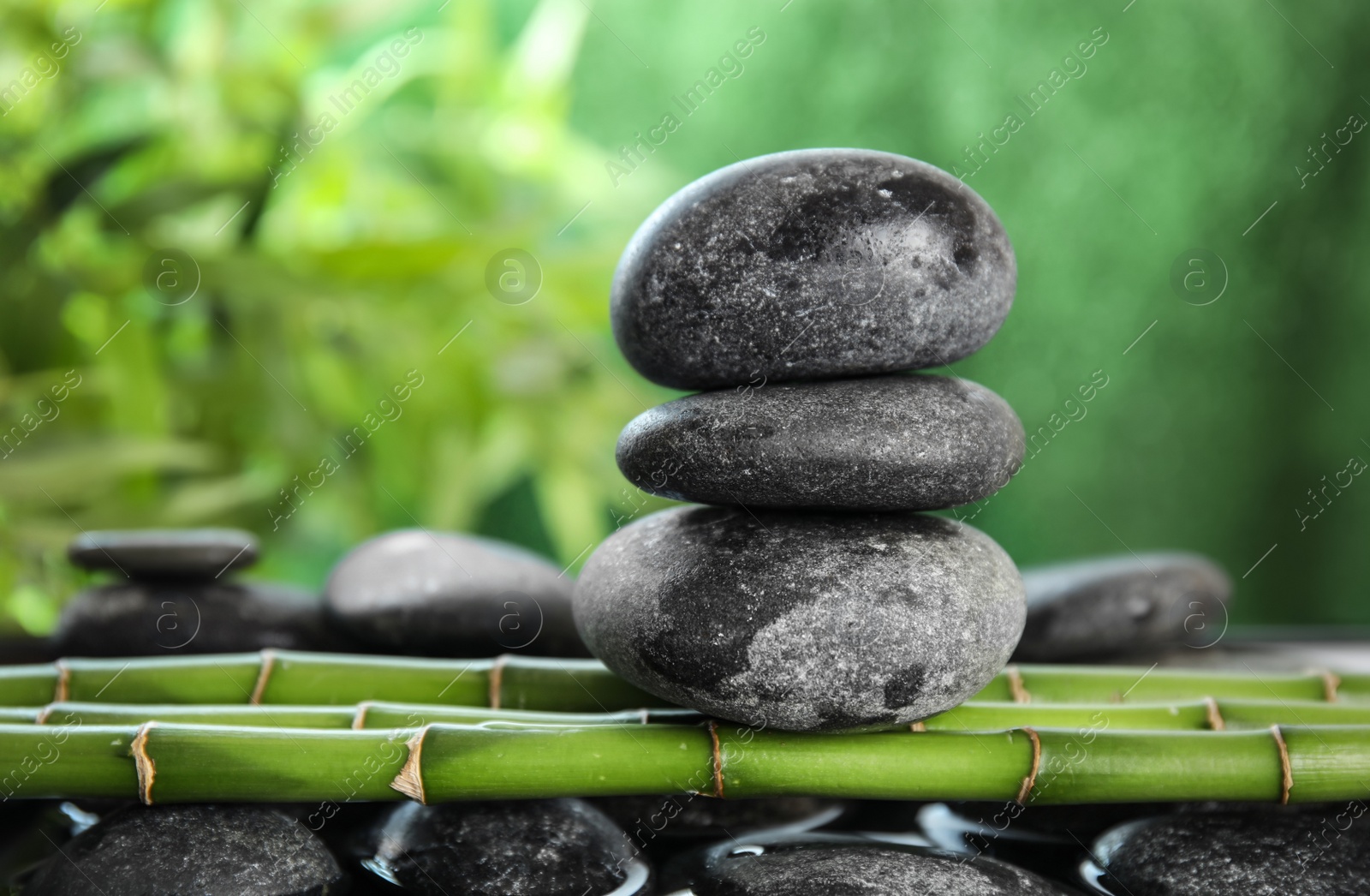 Photo of Zen stones on bamboo against blurred background