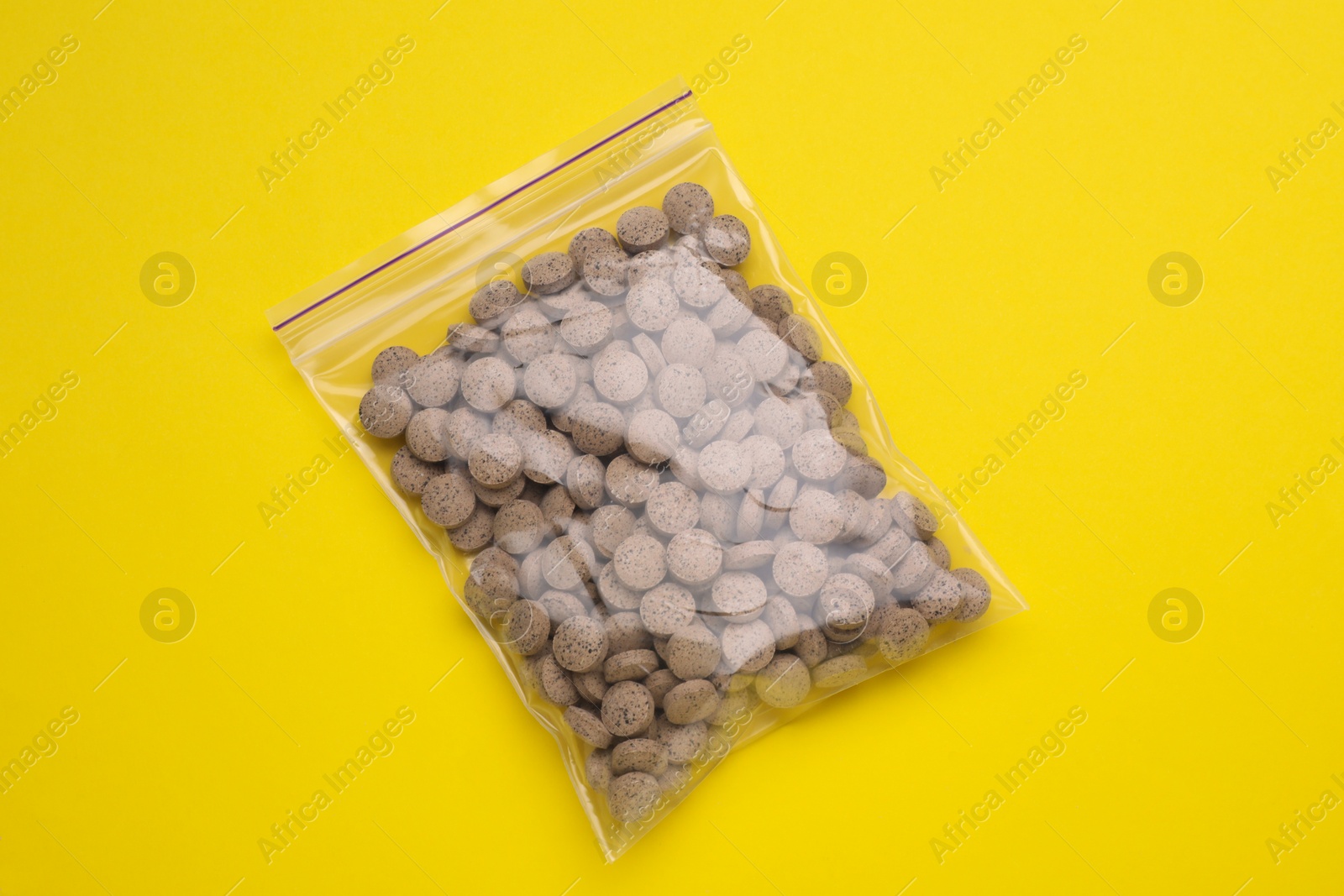 Photo of Beer yeast pills on yellow background, top view