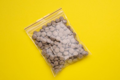 Beer yeast pills on yellow background, top view