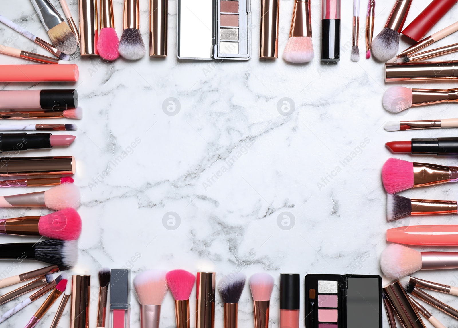 Photo of Frame of different makeup products on white marble table, flat lay. Space for text