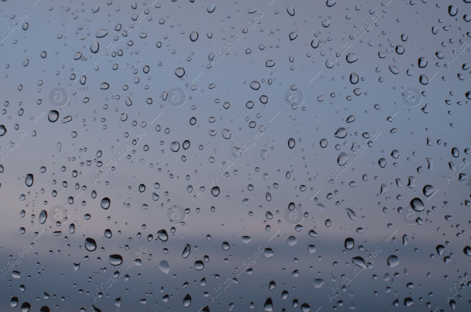 Photo of Window glass with water drops, closeup. Rainy weather