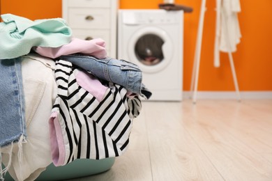 Photo of Laundry basket filled with clothes in bathroom, closeup. Space for text