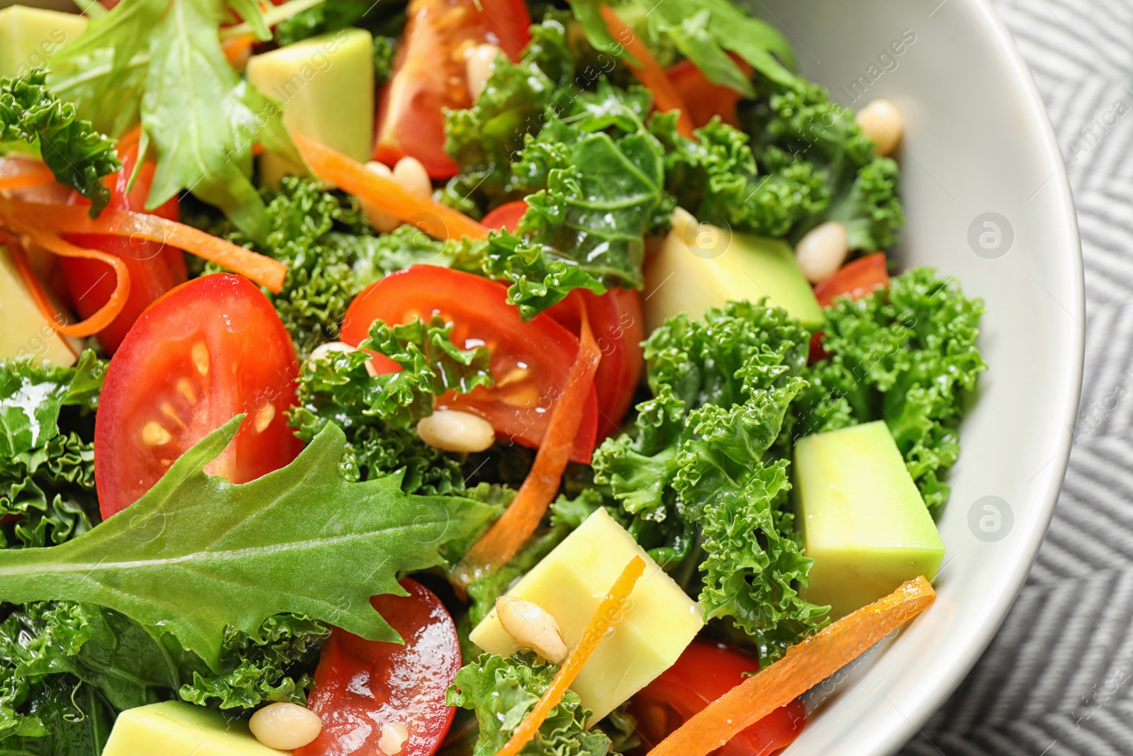 Photo of Tasty fresh kale salad on table, closeup