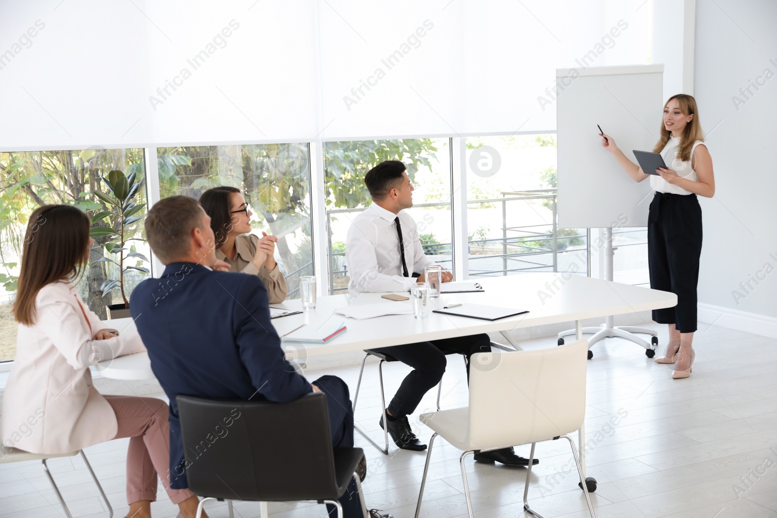 Photo of Female business coach talking to audience in office