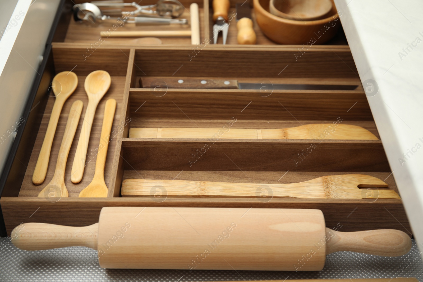 Photo of Open drawer of kitchen cabinet with different utensils, closeup