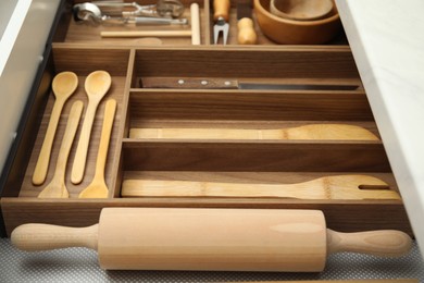 Open drawer of kitchen cabinet with different utensils, closeup