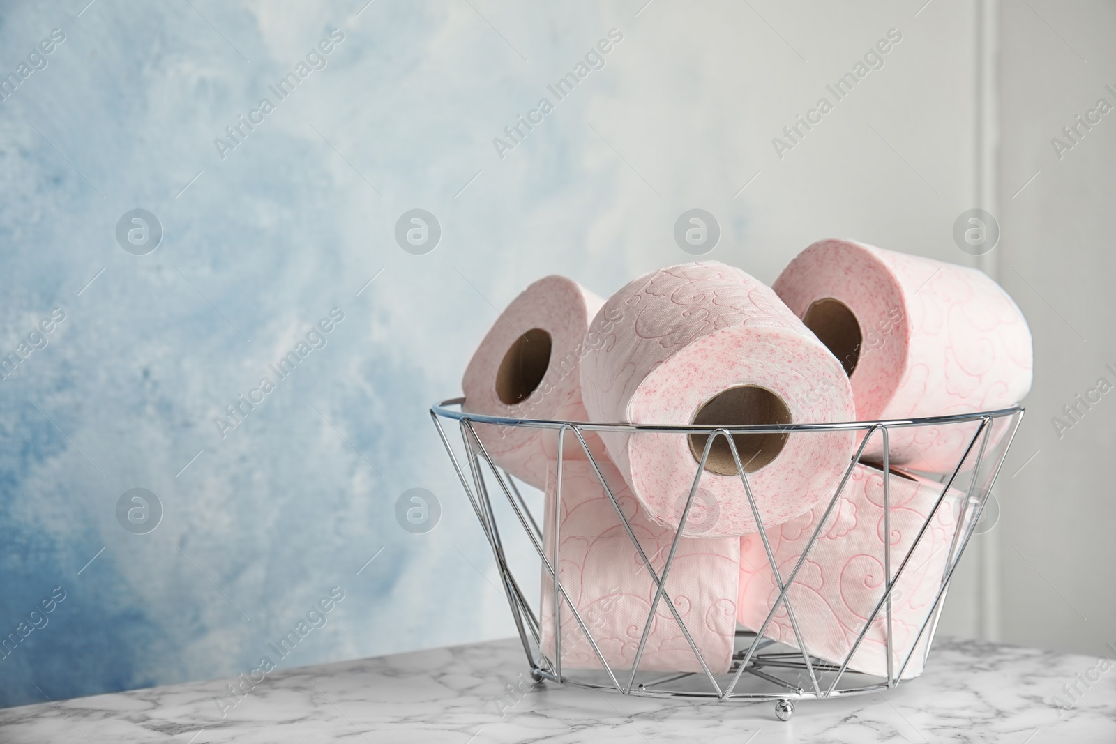 Photo of Bowl with toilet paper rolls on table. Space for text