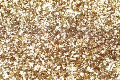 Photo of Beautiful golden shiny glitter as background, top view