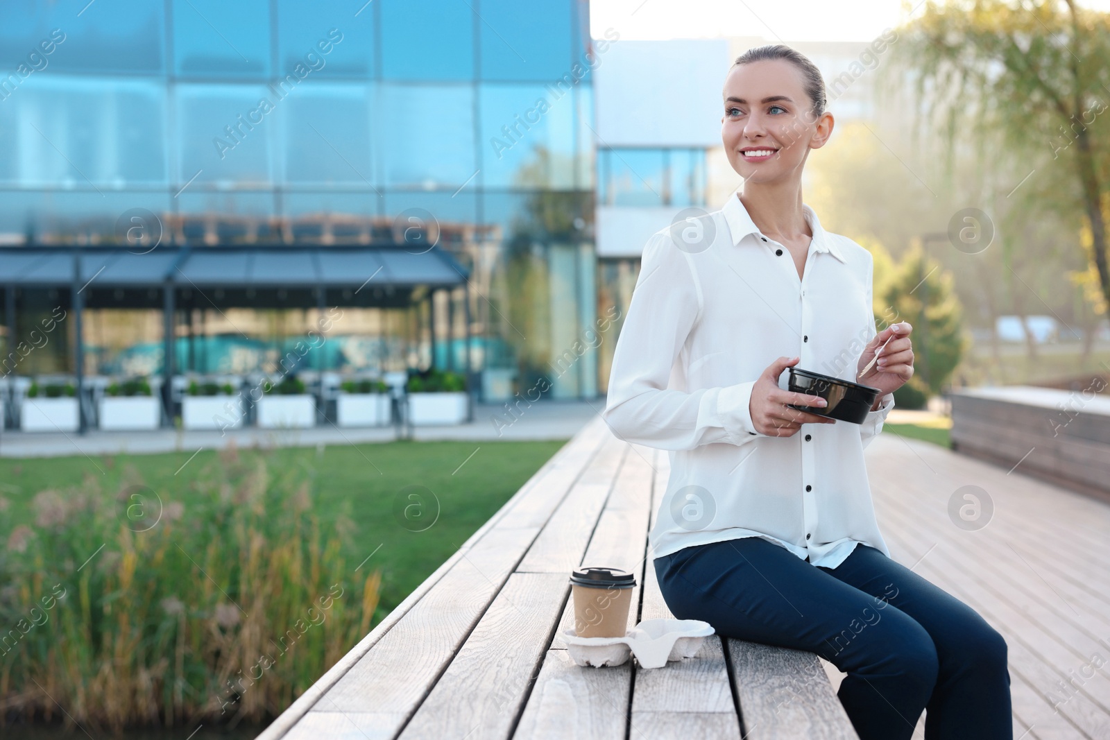 Photo of Smiling businesswoman with lunch box outdoors. Space for text