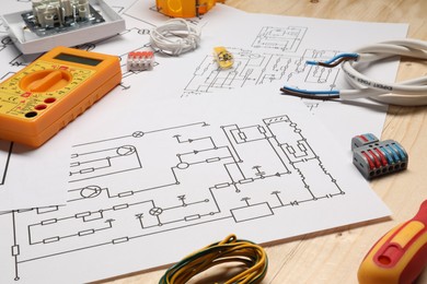 Wiring diagrams and different electrician's equipment on wooden table