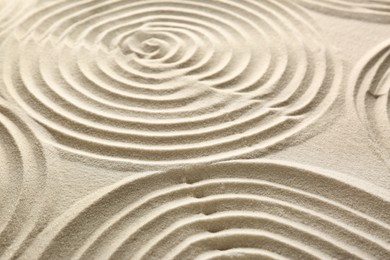 Beautiful spirals on sand, closeup. Zen garden