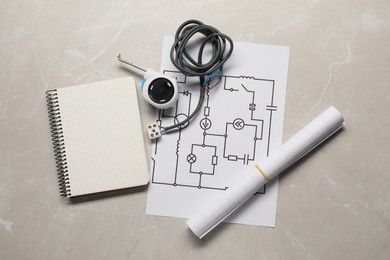 Photo of Wiring diagram, wires, tape measure and notepad on light table, flat lay