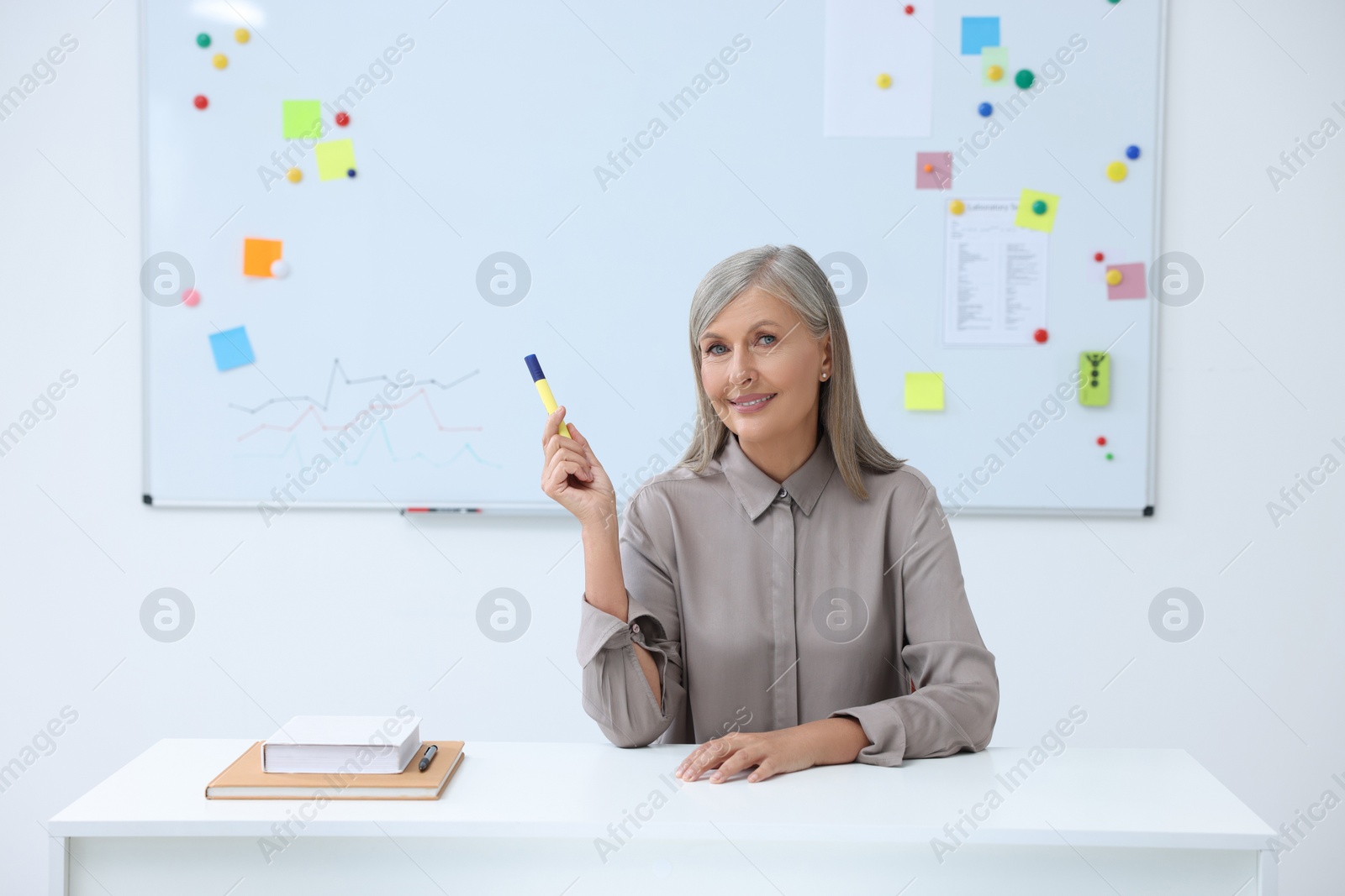 Photo of Happy professor giving lecture at desk in classroom, space for text