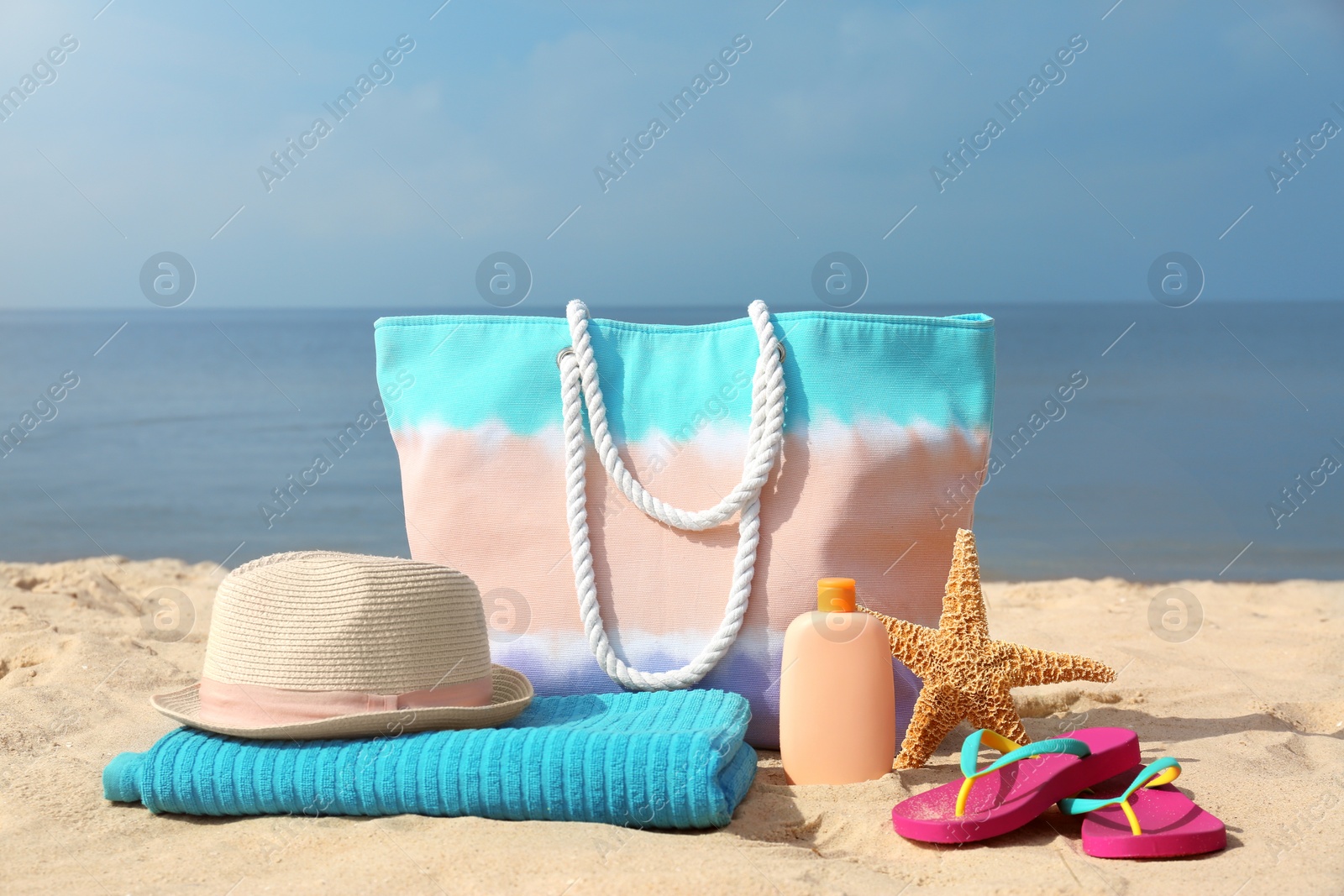 Photo of Set of different stylish beach accessories on sand