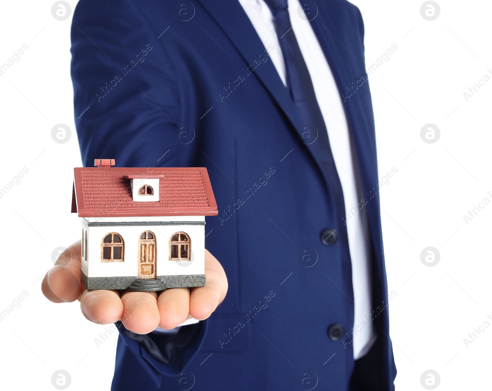 Photo of Real estate agent holding house model on white background, closeup