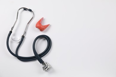 Photo of Endocrinology. Stethoscope and model of thyroid gland on white background, top view. Space for text