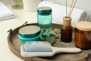 Hair care cosmetic products and brush on table indoors