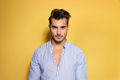 Photo of Young man with trendy hairstyle posing on color background