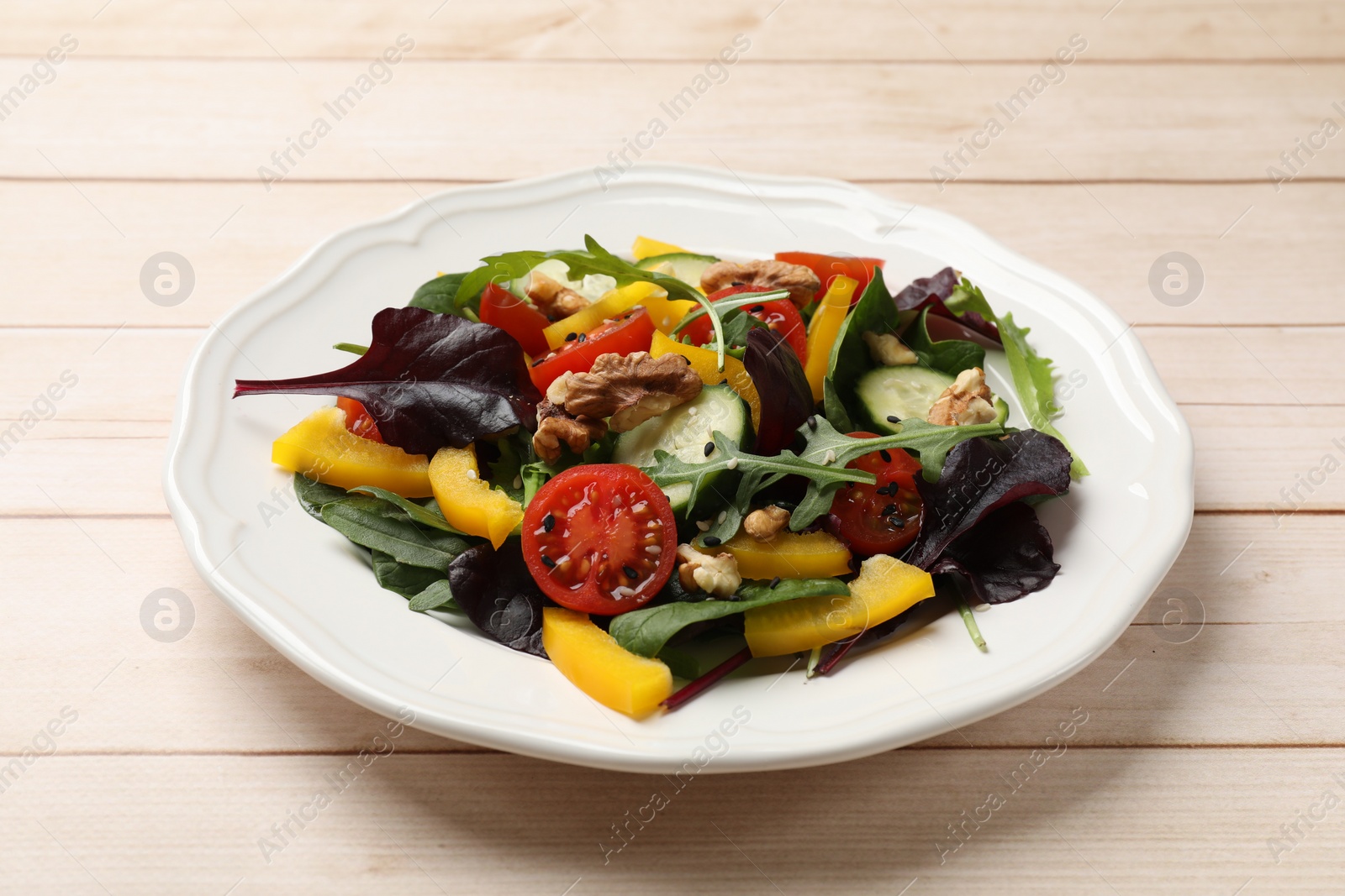 Photo of Tasty fresh vegetarian salad on light wooden table