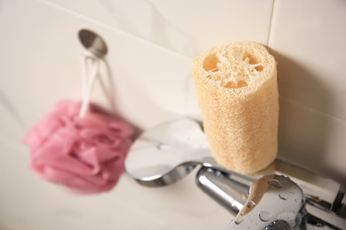 Photo of Pink shower puff and loofah sponge in bathroom, closeup