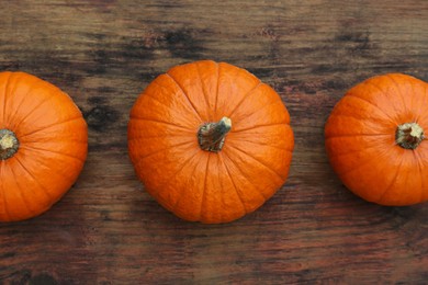 Photo of Fresh ripe pumpkins on wooden table, flat lay