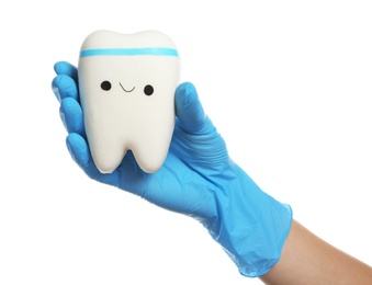 Dentist holding model of tooth with cute face on white background