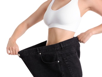 Photo of Young slim woman wearing oversized jeans on white background, closeup