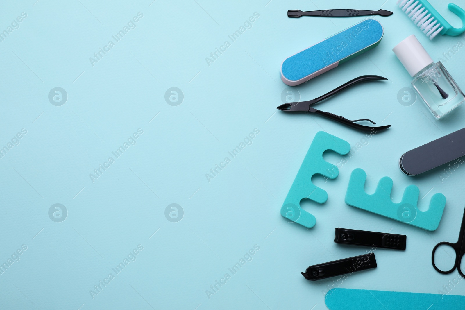 Photo of Set of pedicure tools on light blue background, flat lay. Space for text