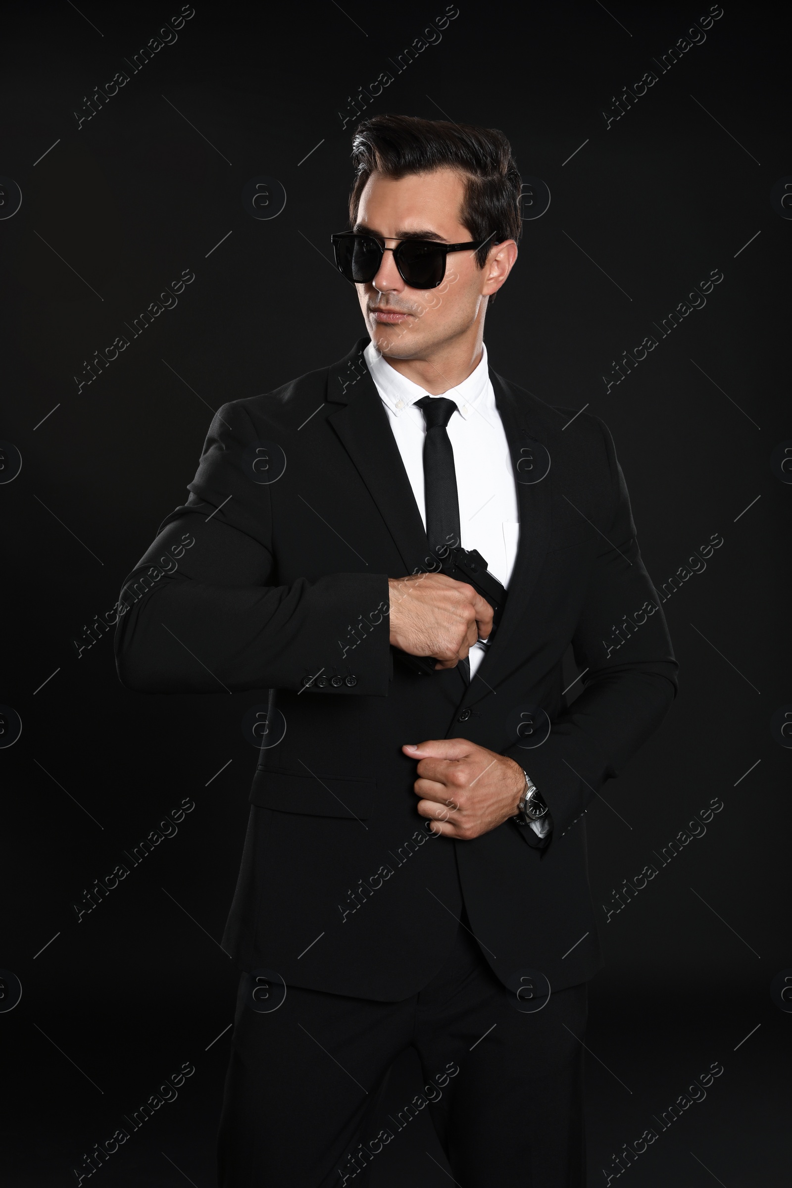 Photo of Male security guard in uniform with gun on dark background