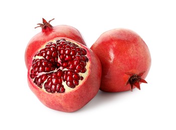 Photo of Many fresh ripe pomegranates isolated on white