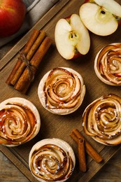 Photo of Freshly baked apple roses on wooden table, flat lay. Beautiful dessert