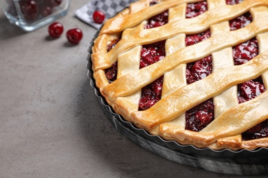 Photo of Delicious fresh cherry pie on grey table, closeup