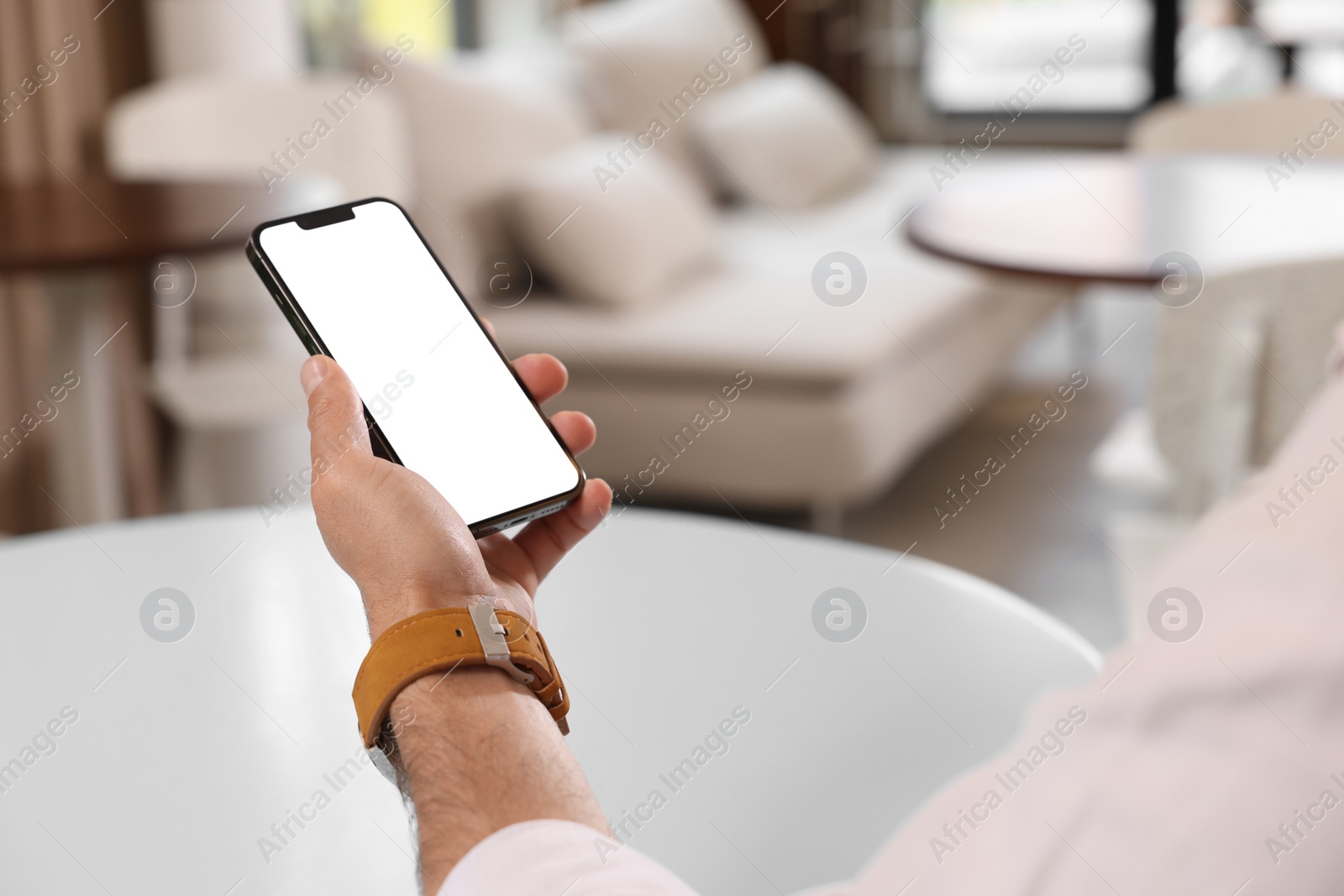 Photo of Man using smartphone at table in cafe, closeup. Space for text