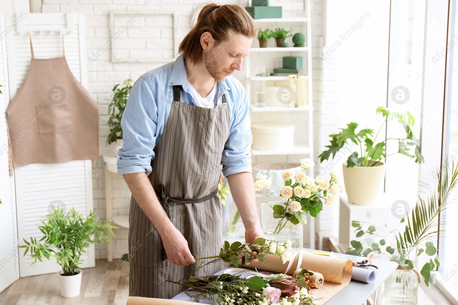 Photo of Male florist creating bouquet at workplace