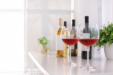 Glasses and bottles with delicious wine on table indoors