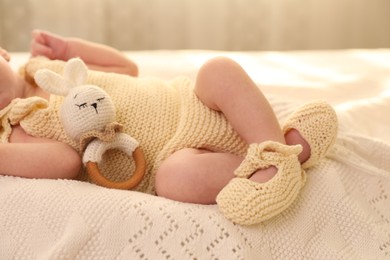 Newborn baby with toy on knitted plaid, closeup