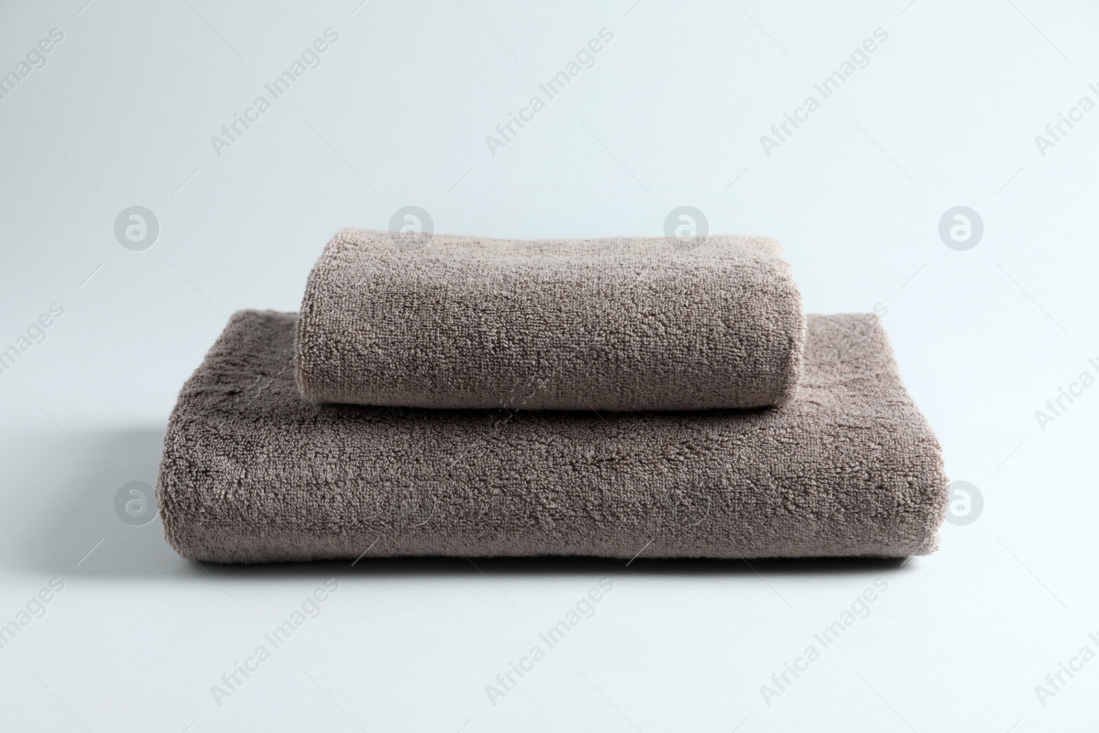 Photo of Stack of fresh fluffy towels on grey background