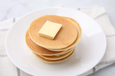 Photo of Delicious pancakes with butter on table, closeup