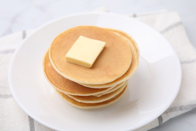 Delicious pancakes with butter on table, closeup