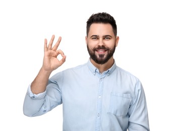 Happy young man with mustache showing OK gesture on white background