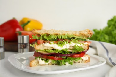 Delicious sandwich with vegetables and cheese on white table, closeup