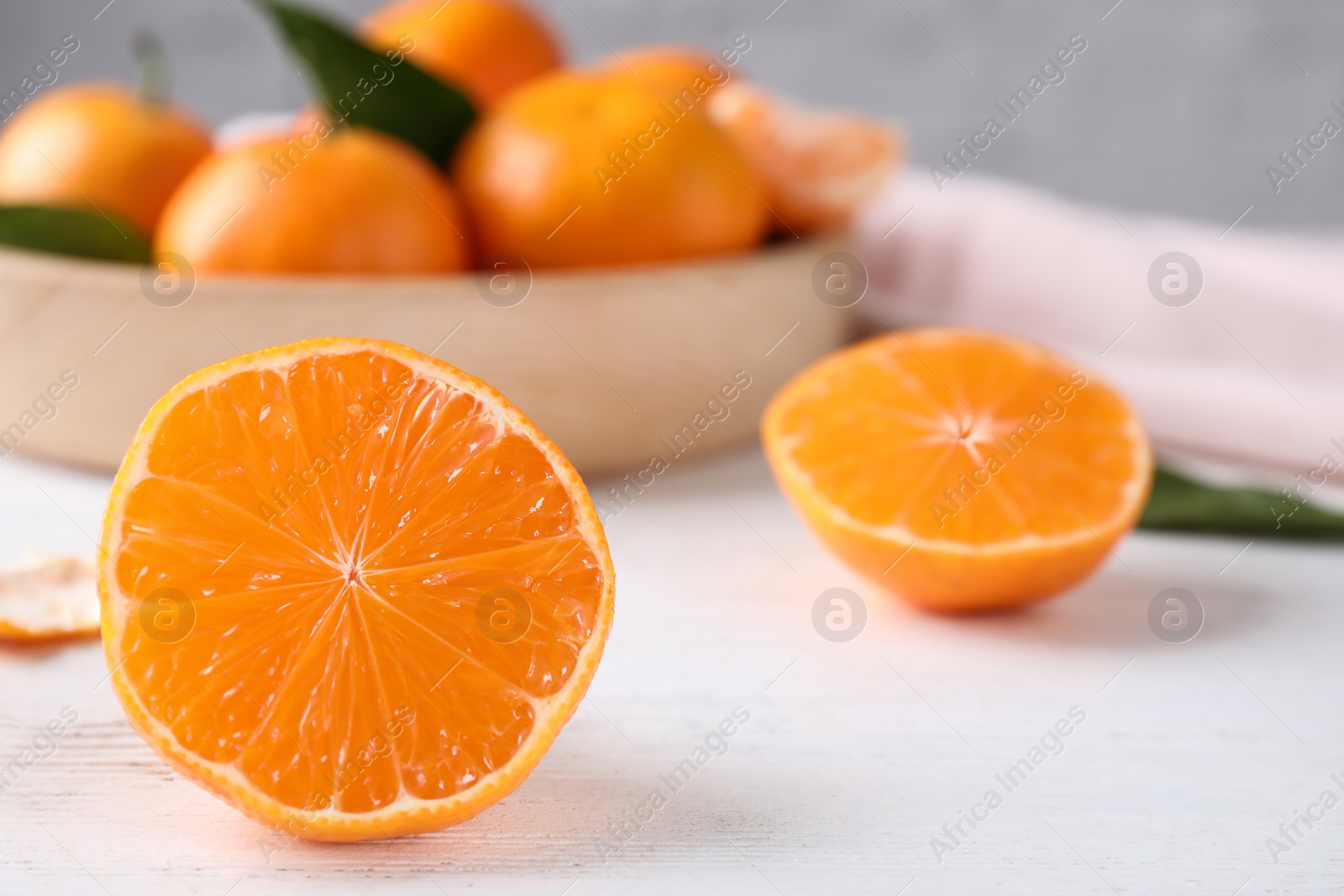 Photo of Cut fresh ripe tangerines on white wooden table