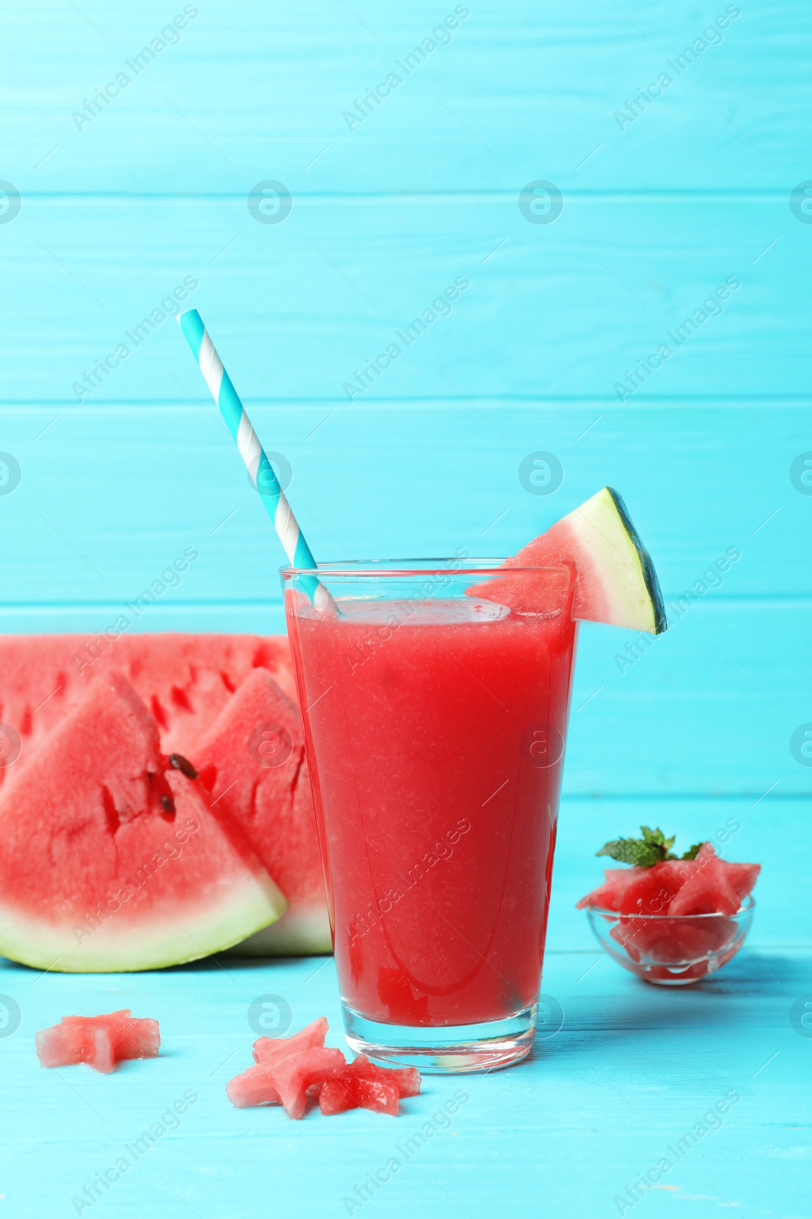 Photo of Summer watermelon drink in glass and sliced fruit on table