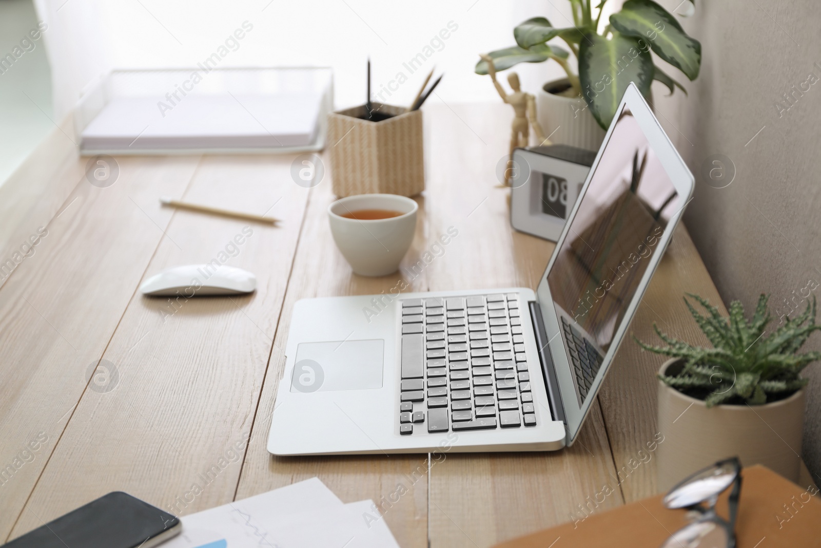 Photo of Stylish workplace with laptop on wooden desk. Interior design