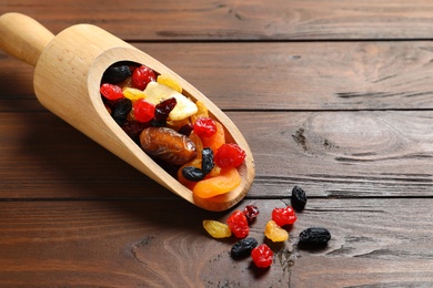 Scoop with different dried fruits on wooden background, space for text. Healthy lifestyle