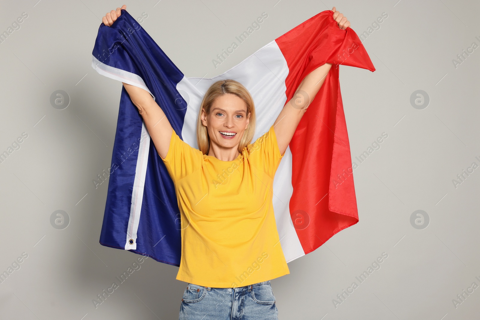 Photo of Woman with flag of France on light grey background