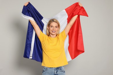 Woman with flag of France on light grey background