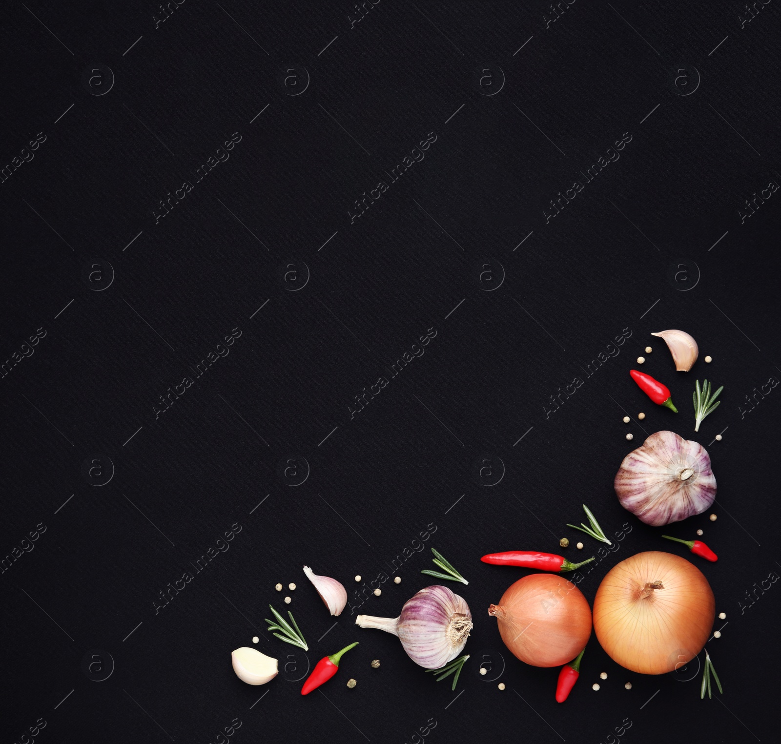 Photo of Flat lay composition with garlic, peppers and onions on black background. Space for text