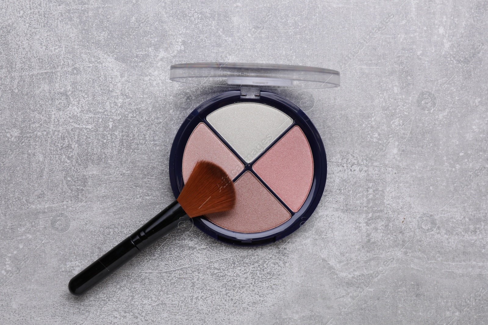 Photo of Contouring palette and brush on light gray background, top view. Professional cosmetic product